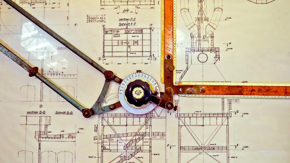 Drafting tools laid over an engineering blueprint.