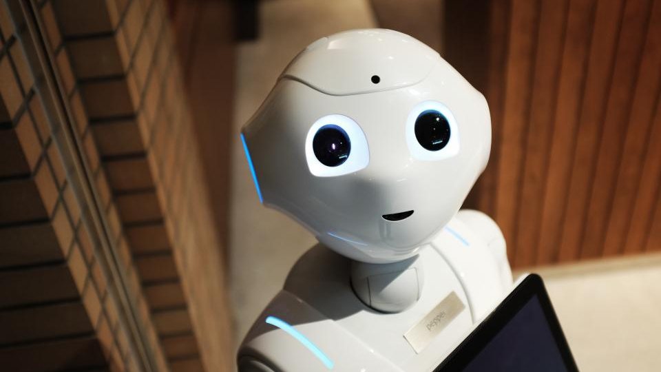A humanoid service robot holding a tablet.